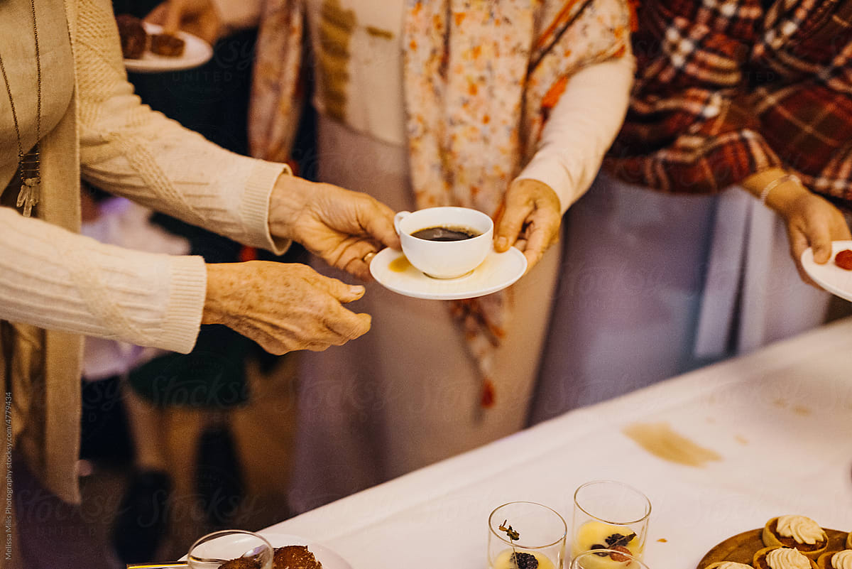 elderly people passing around a coffee