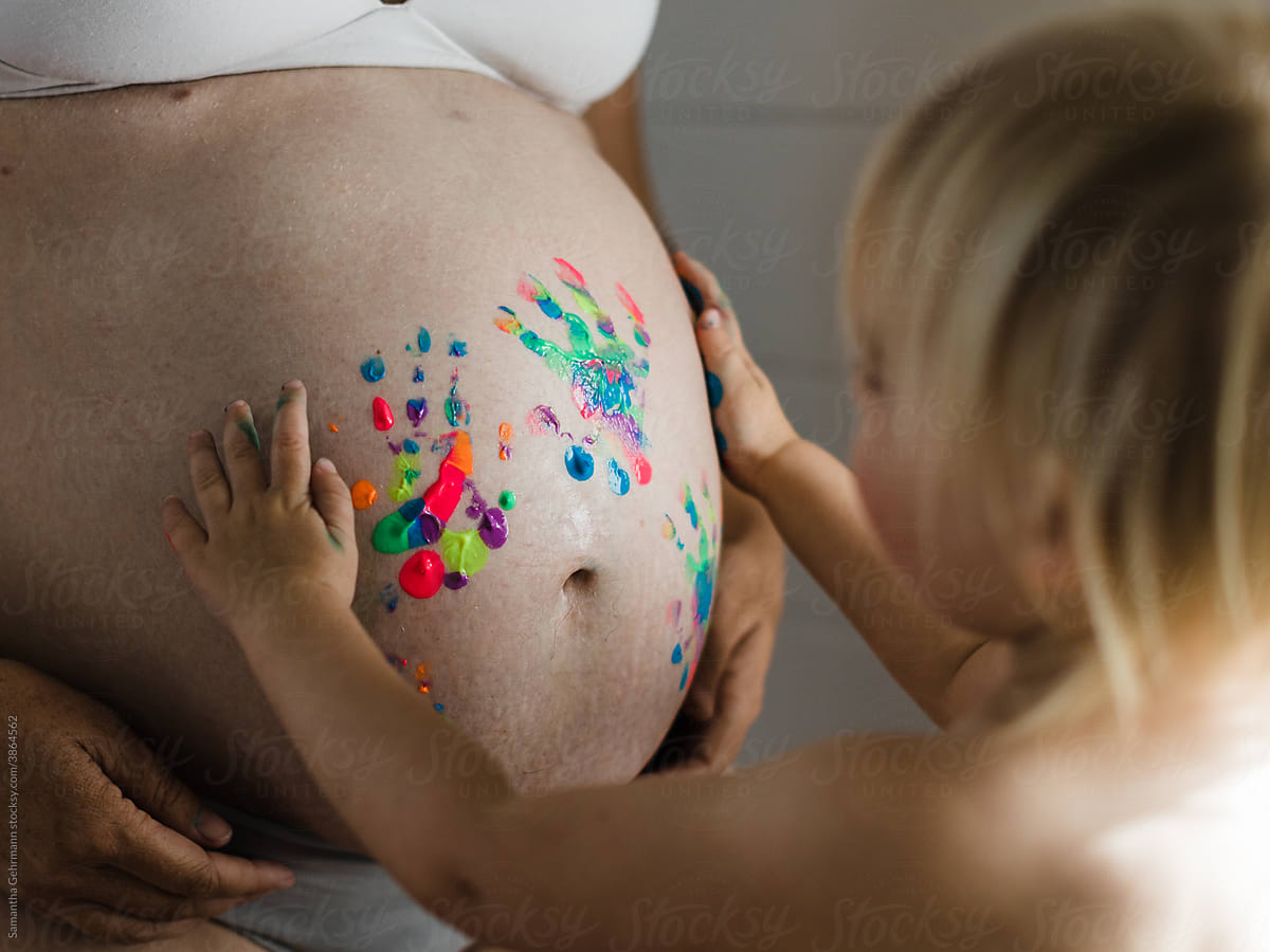 toddler painting pregnant belly