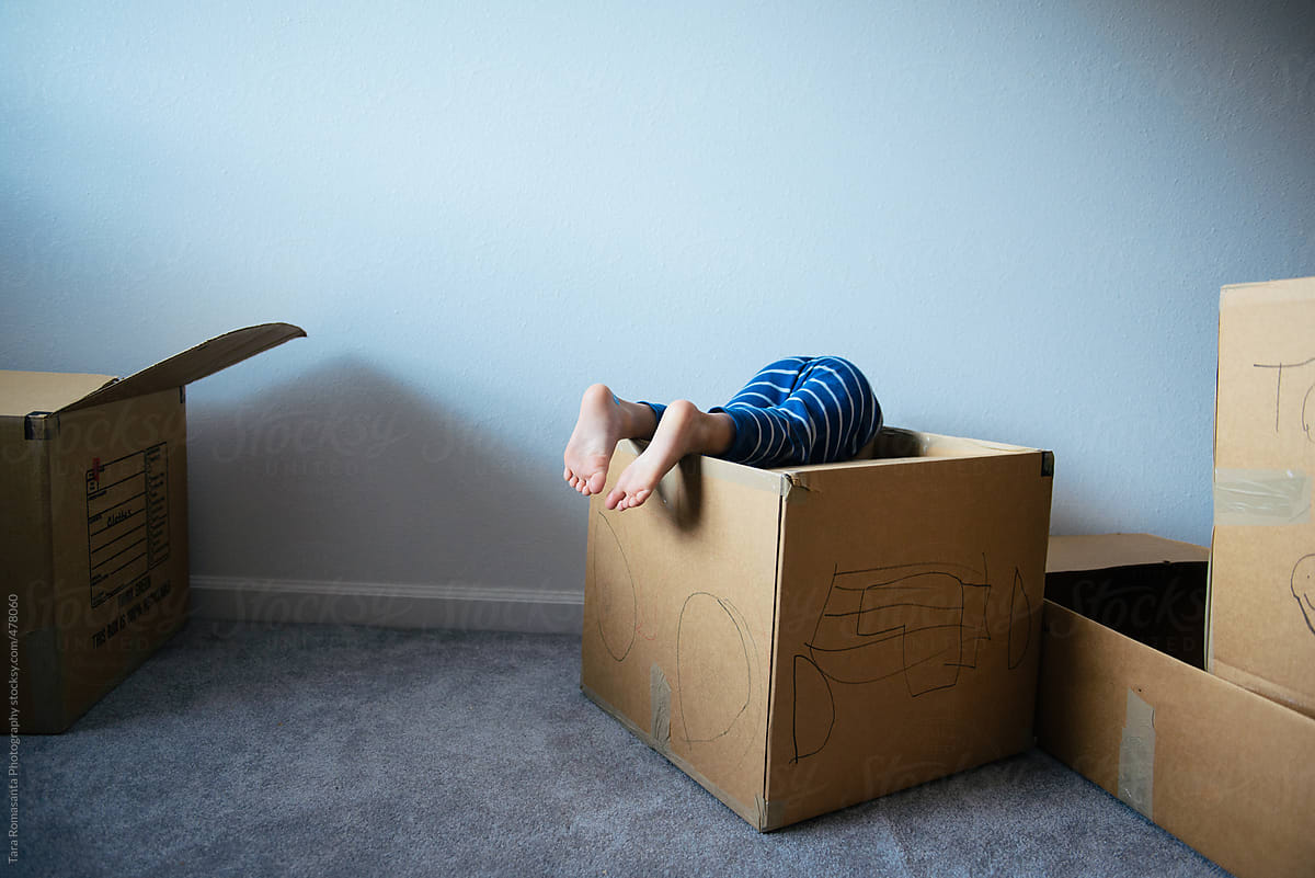 little boy dives into a moving box