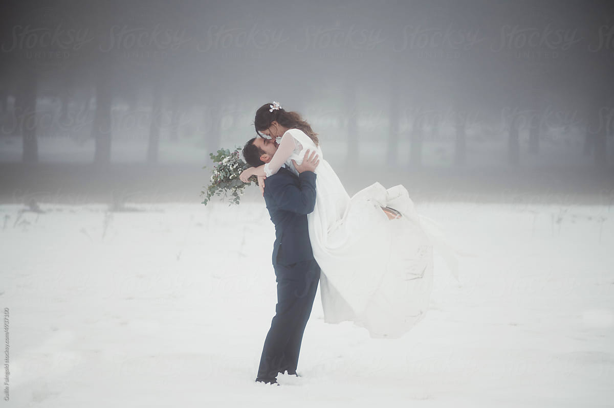 Kissing just married couple in snow.