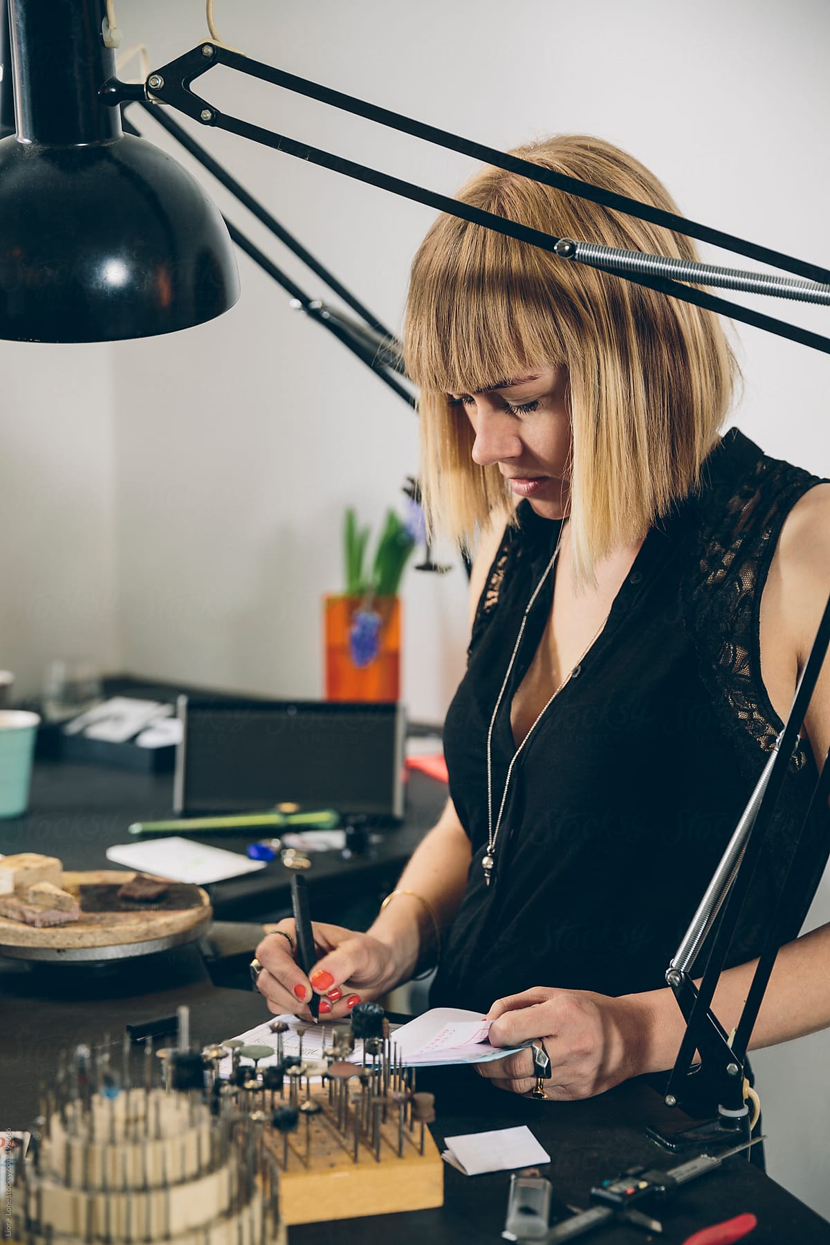 A jewelry designer taking an order in her studio