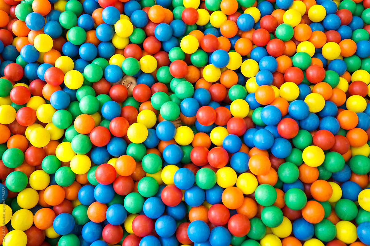 Child hidden among thousands of colored balls