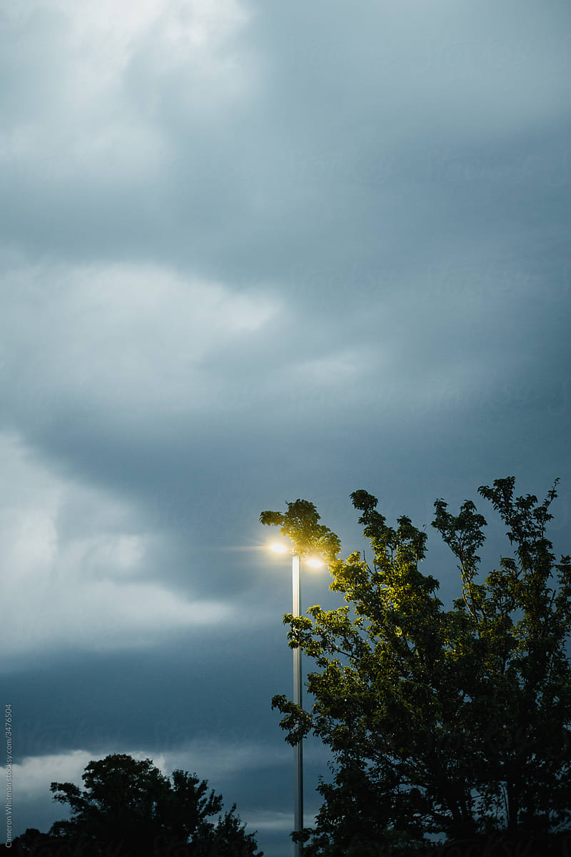 Sturdy and tall parking lot lights against an ominous sky