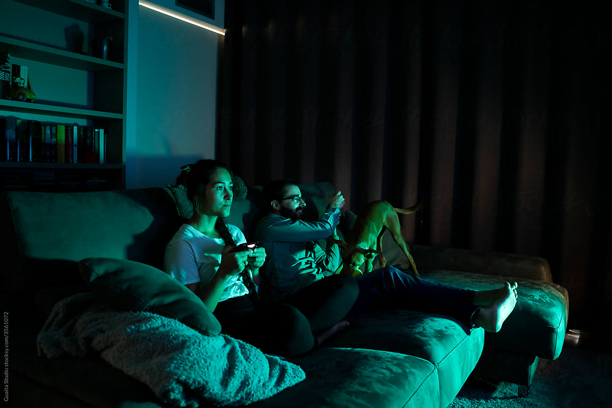 Happy couple playing videogames at night