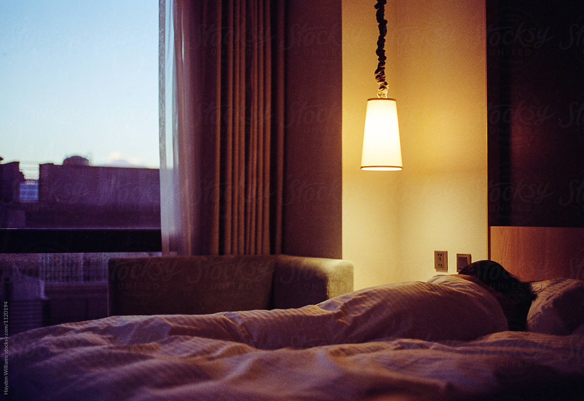 Girl Peacefully Sleeping In A Fluffy Comfortable Bed In A Bedroom Or Hotel Room During Sunrise
