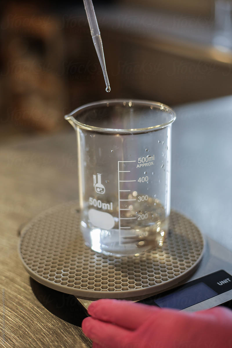 Anonymous Scientist Measuring Liquid in Beaker