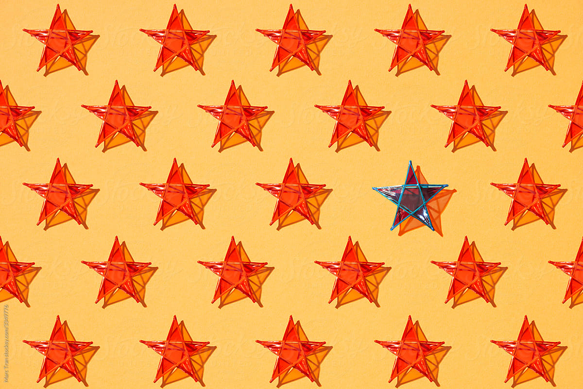 One blue star standing among other red stars