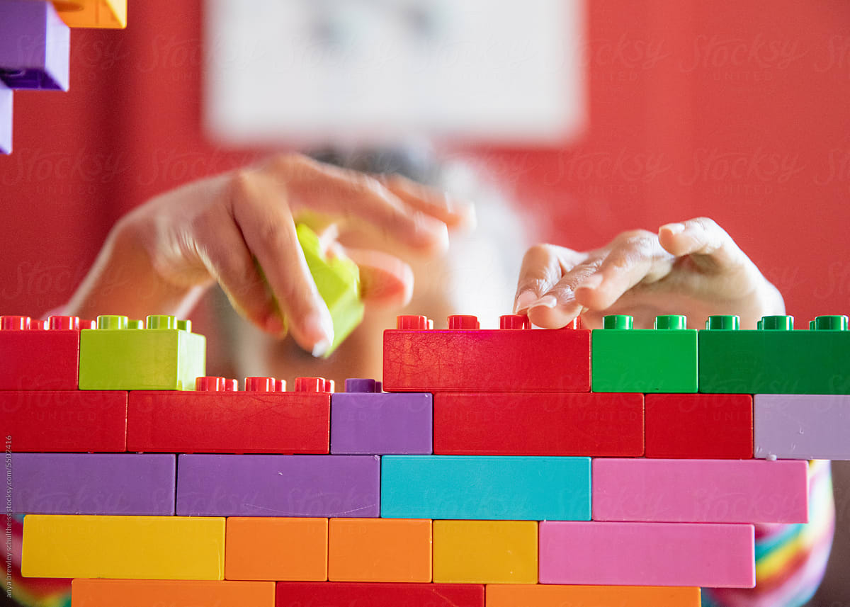 Closeup of child building lego blocks