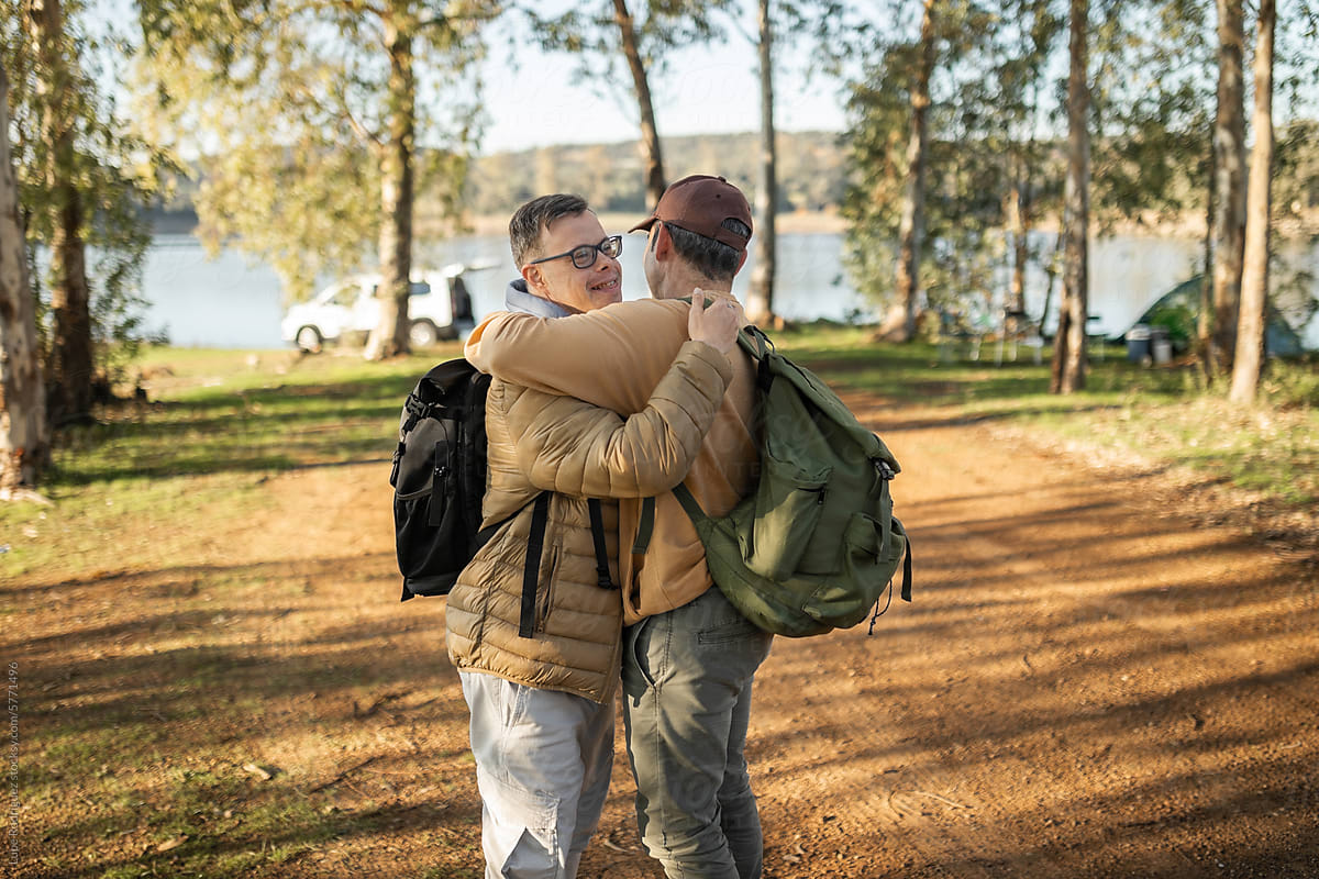 man with syndrome hugging his friend in nature