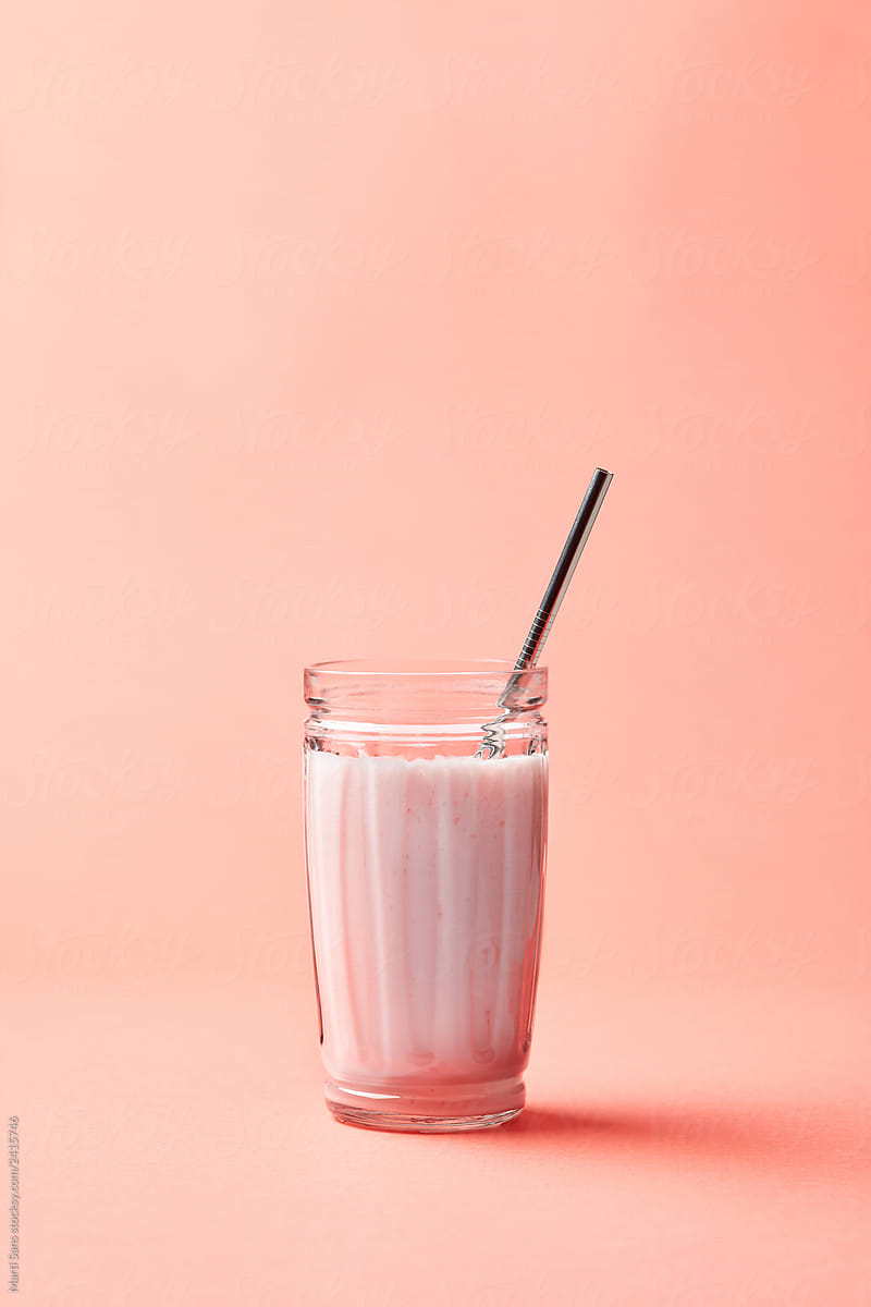 Glass of pink drink with steel straw