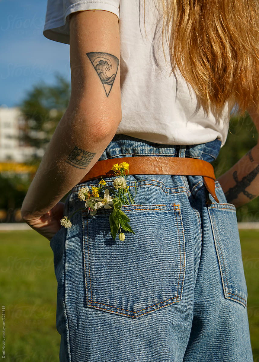 Crop tender woman with flowers in pocket