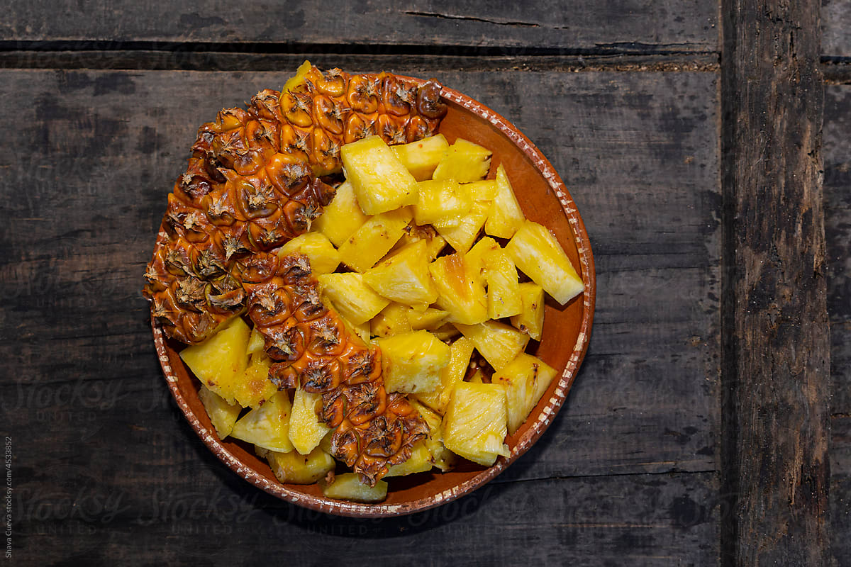 Chopped pineapple and pineapple skins in a clay dish