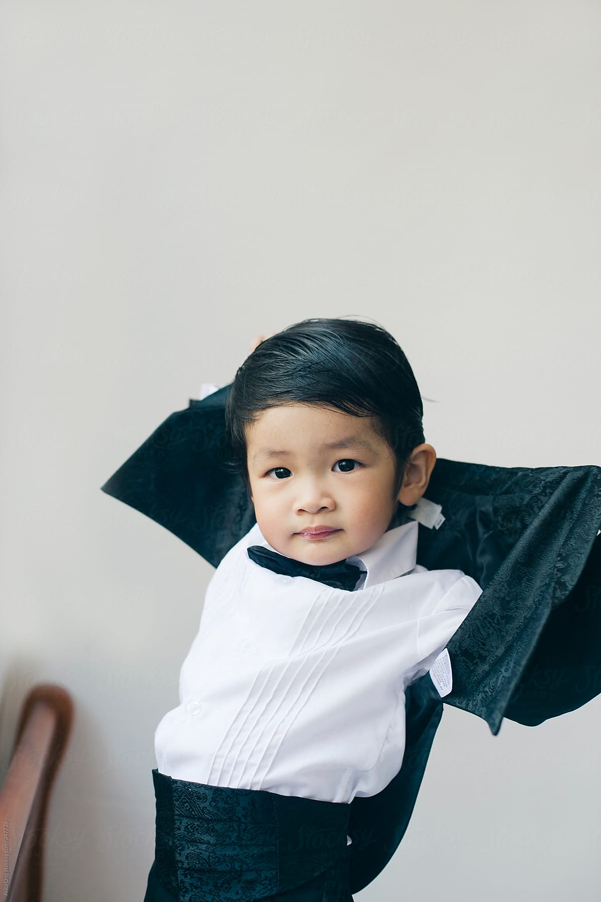 Asian toddler wearing tuxedo
