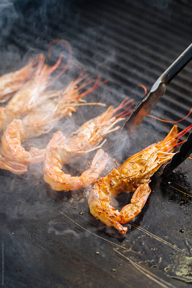 Cook flipping Shrimp on a Grill