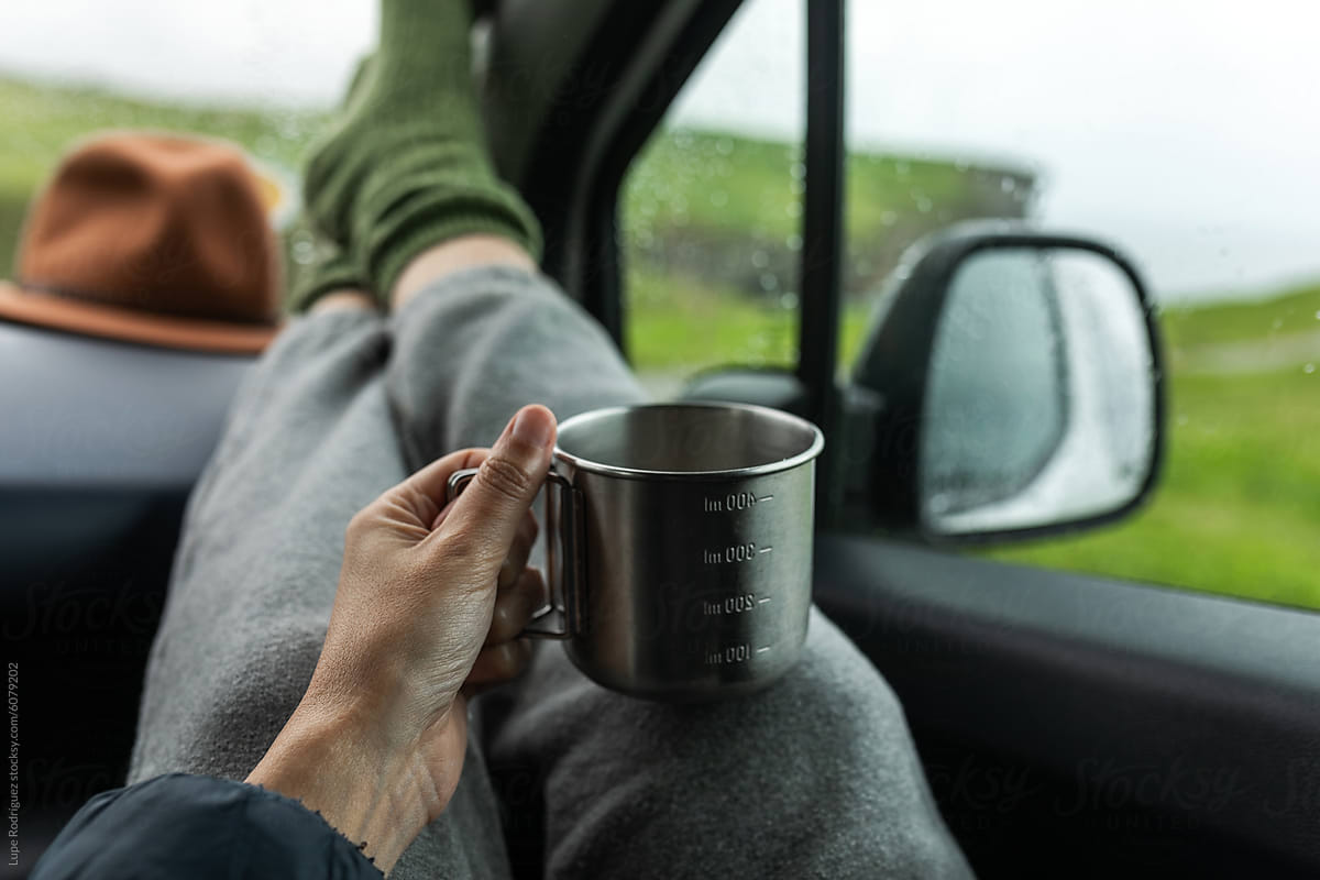 Anonymous hand of a woman having a coffee inside a van