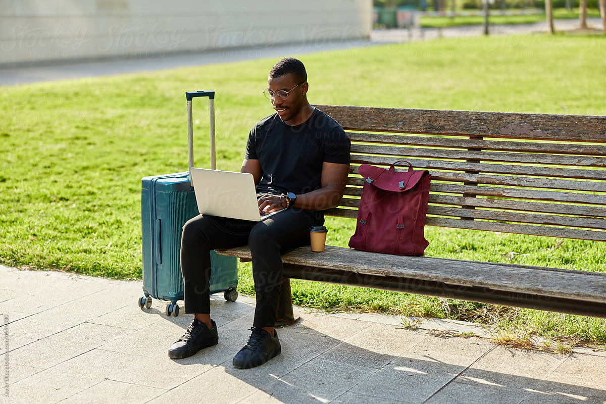 Black self employed man working on netbook in park
