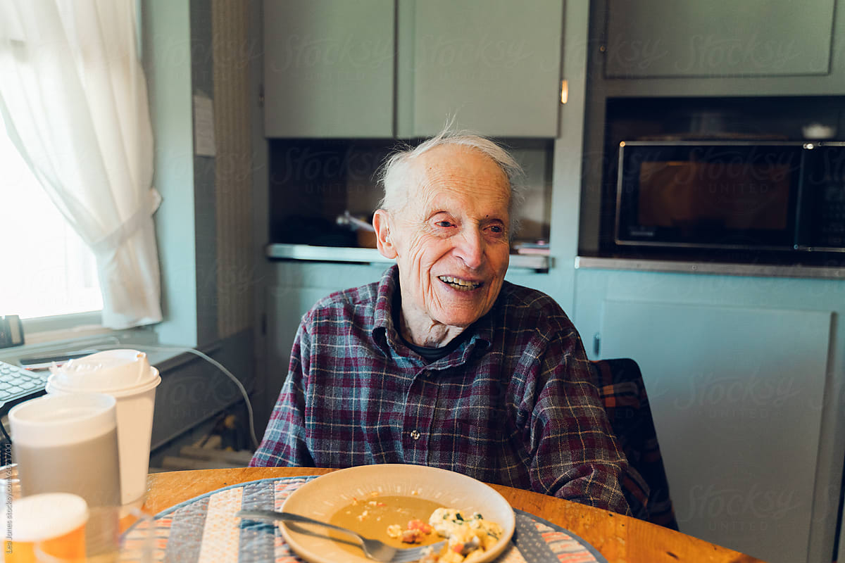 portrait of happy and smiling senior citizen at the breakfast table