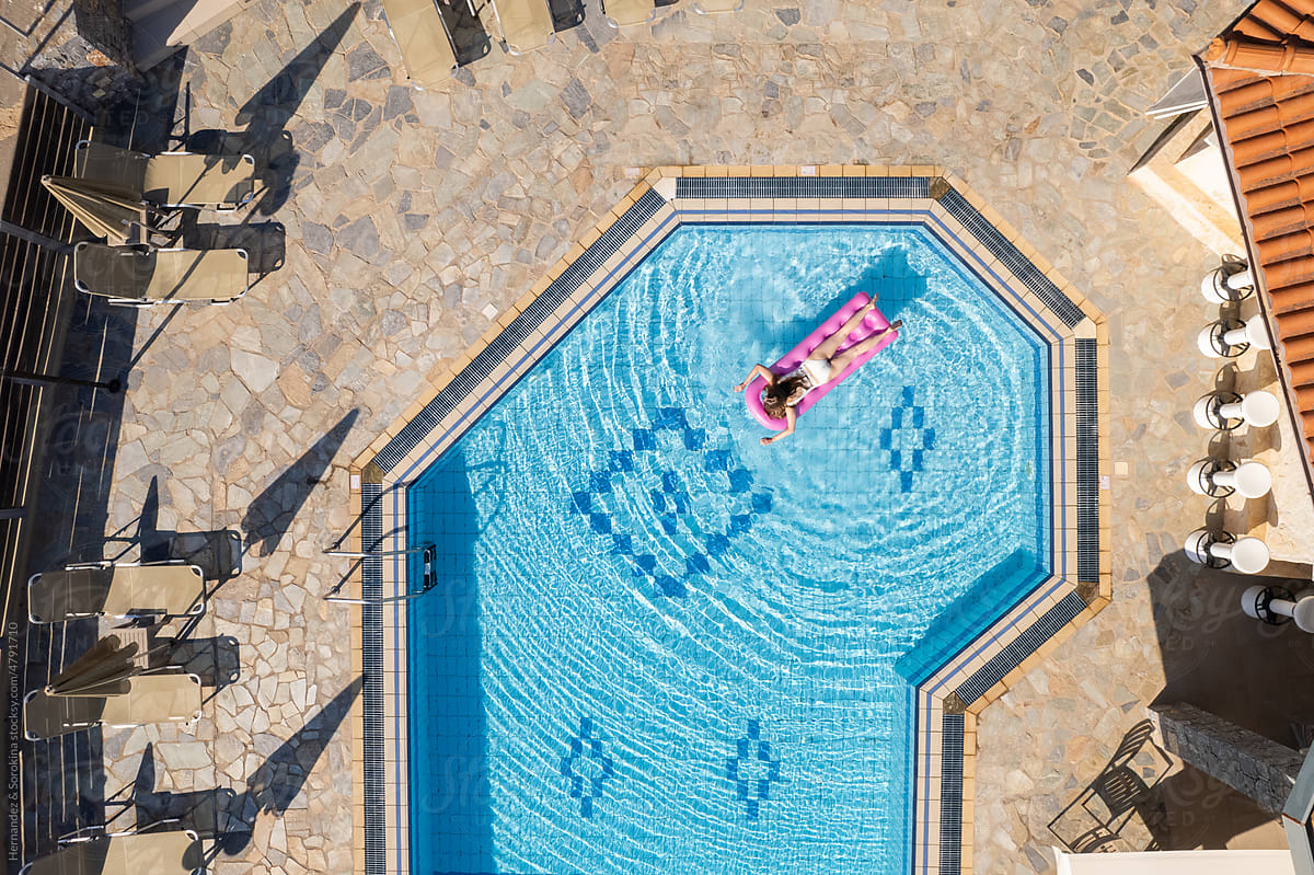 Aerial Image Of Woman Floating On Air Mattress In Pool
