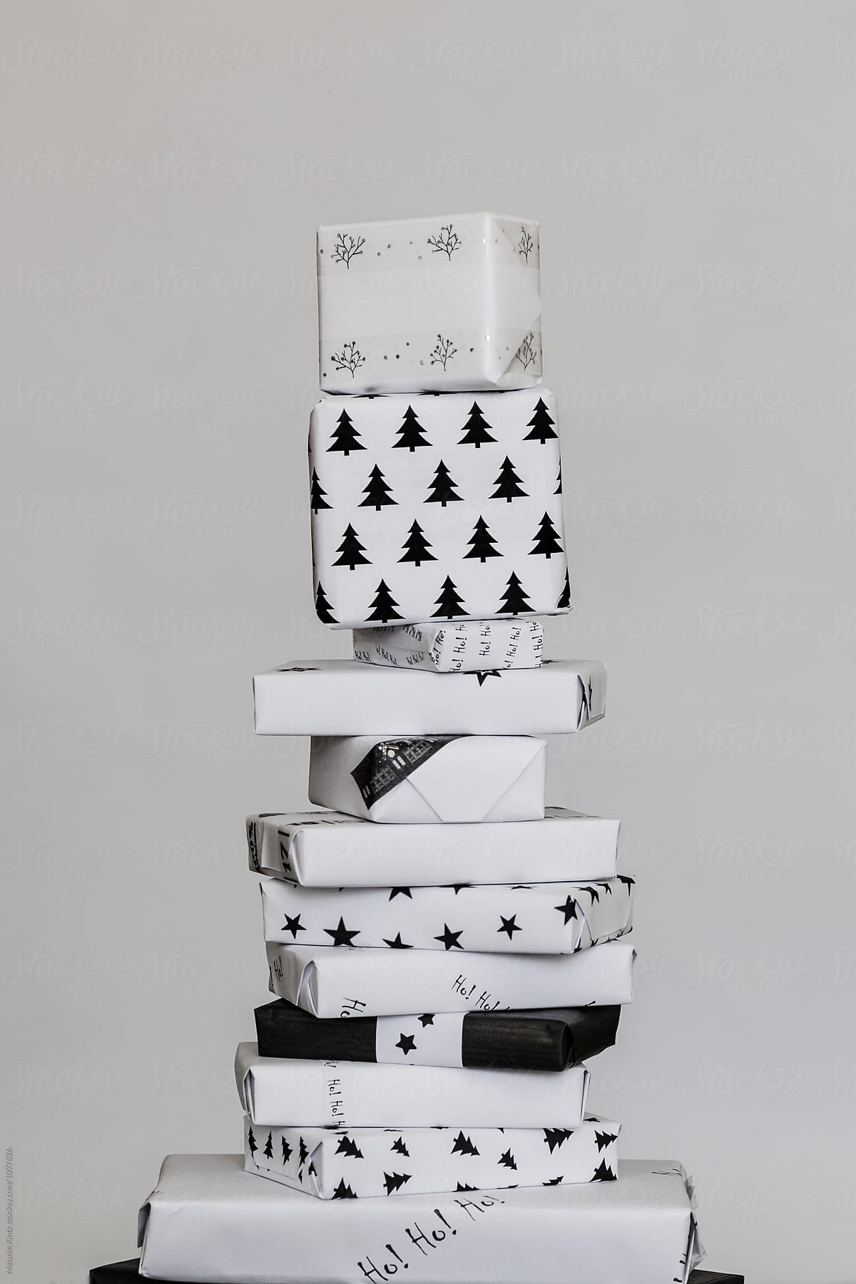 Tall stack of Christmas gifts wrapped in black and white