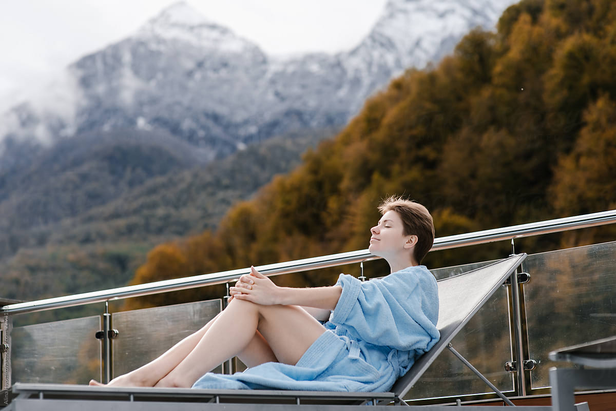Relaxing woman in bathrobe on resort terrace