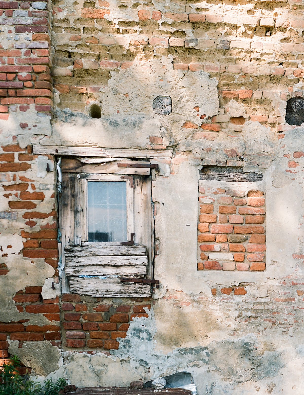 Damaged antique wooden window in ruined brick building in Italy