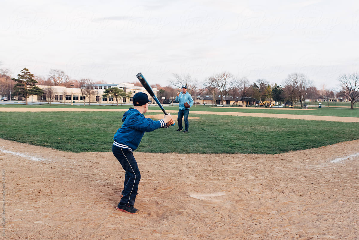 Boy getting ready to hit a ball thrown by his Dad on a baseball