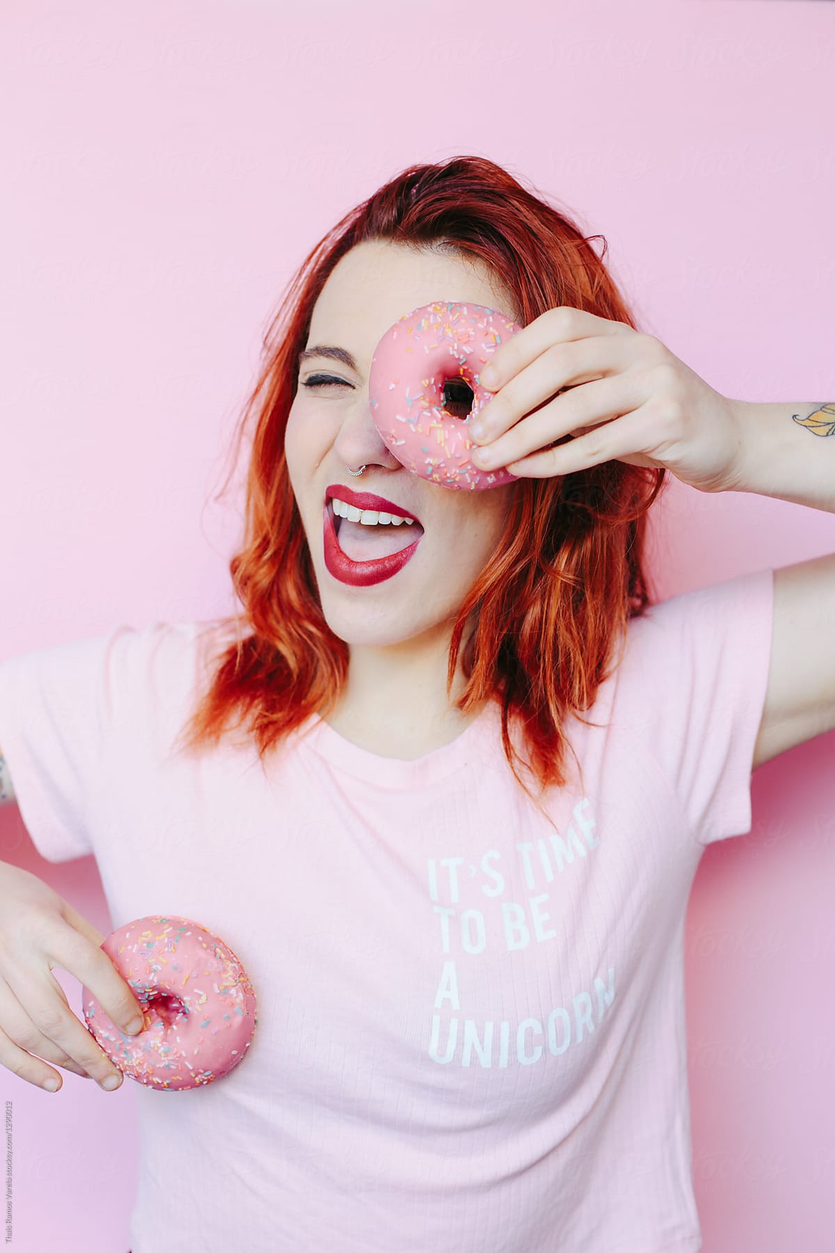 woman covering her face and her boob with a pink doughnut