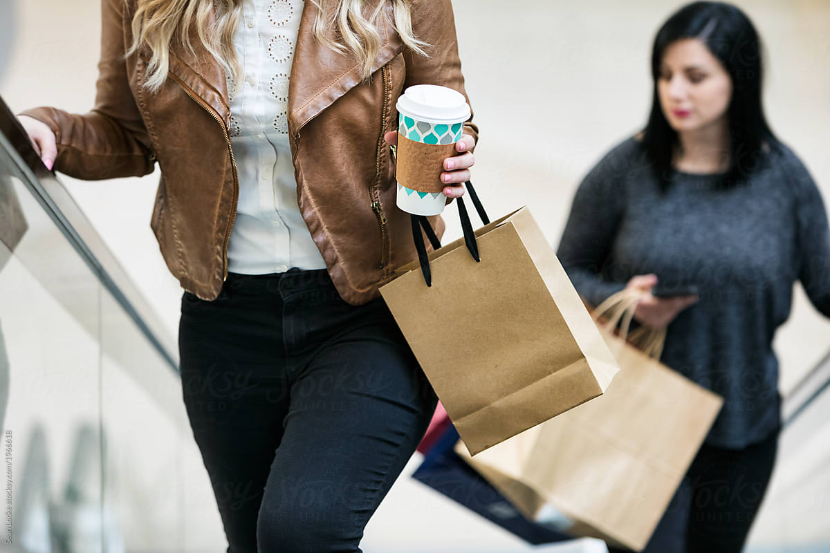 Mall: Anonymous Woman With Coffee Riding Escalator