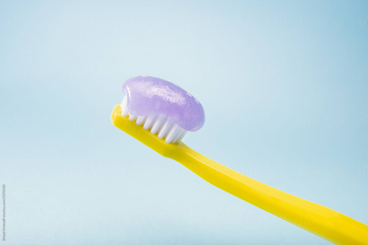 Yellow Toothbrush And Toothpaste On Blue Background