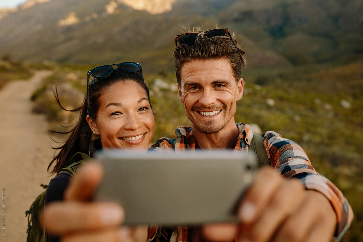 Young man and woman taking selfie on country hike