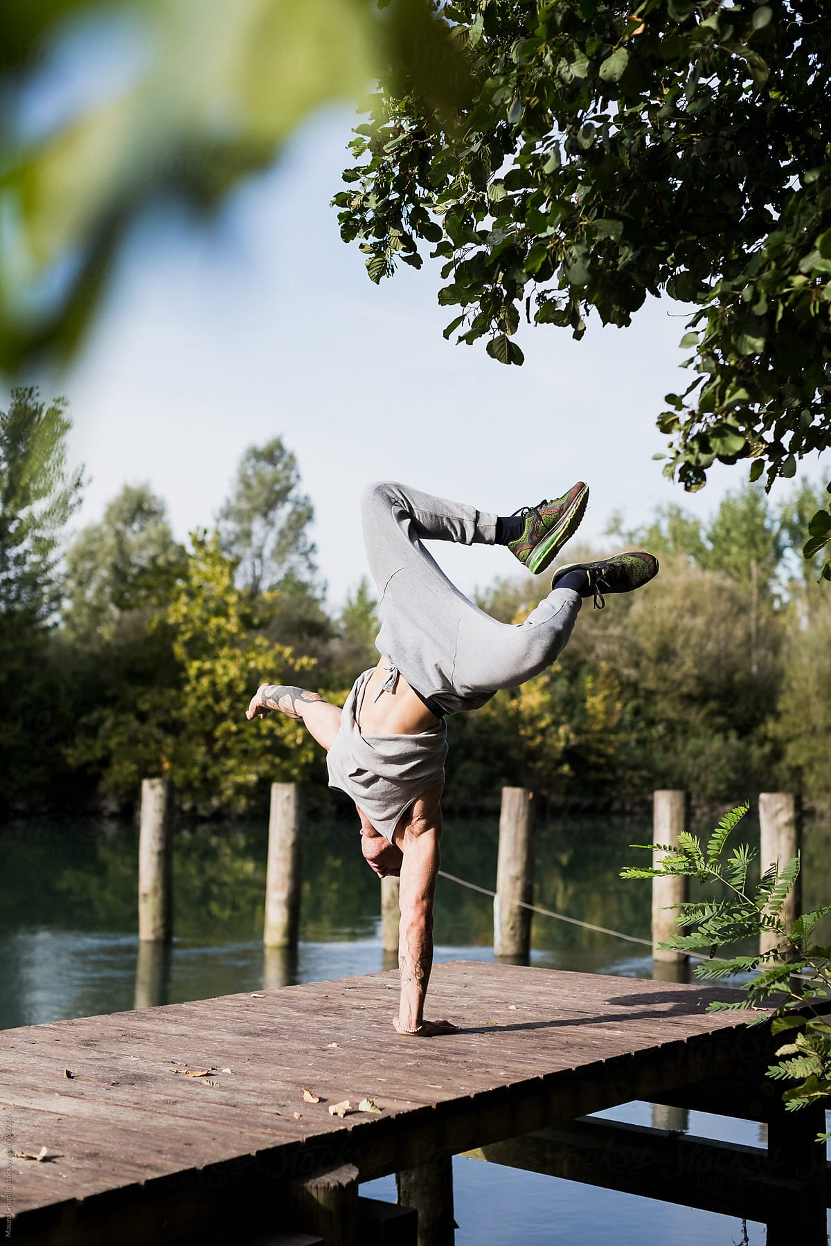 Man doing one arm Handstand in a jetty
