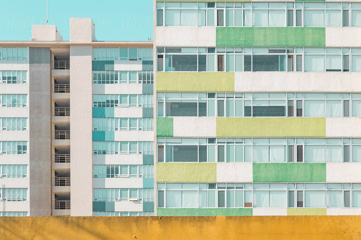 The front of two apartment buildings with colored balconies
