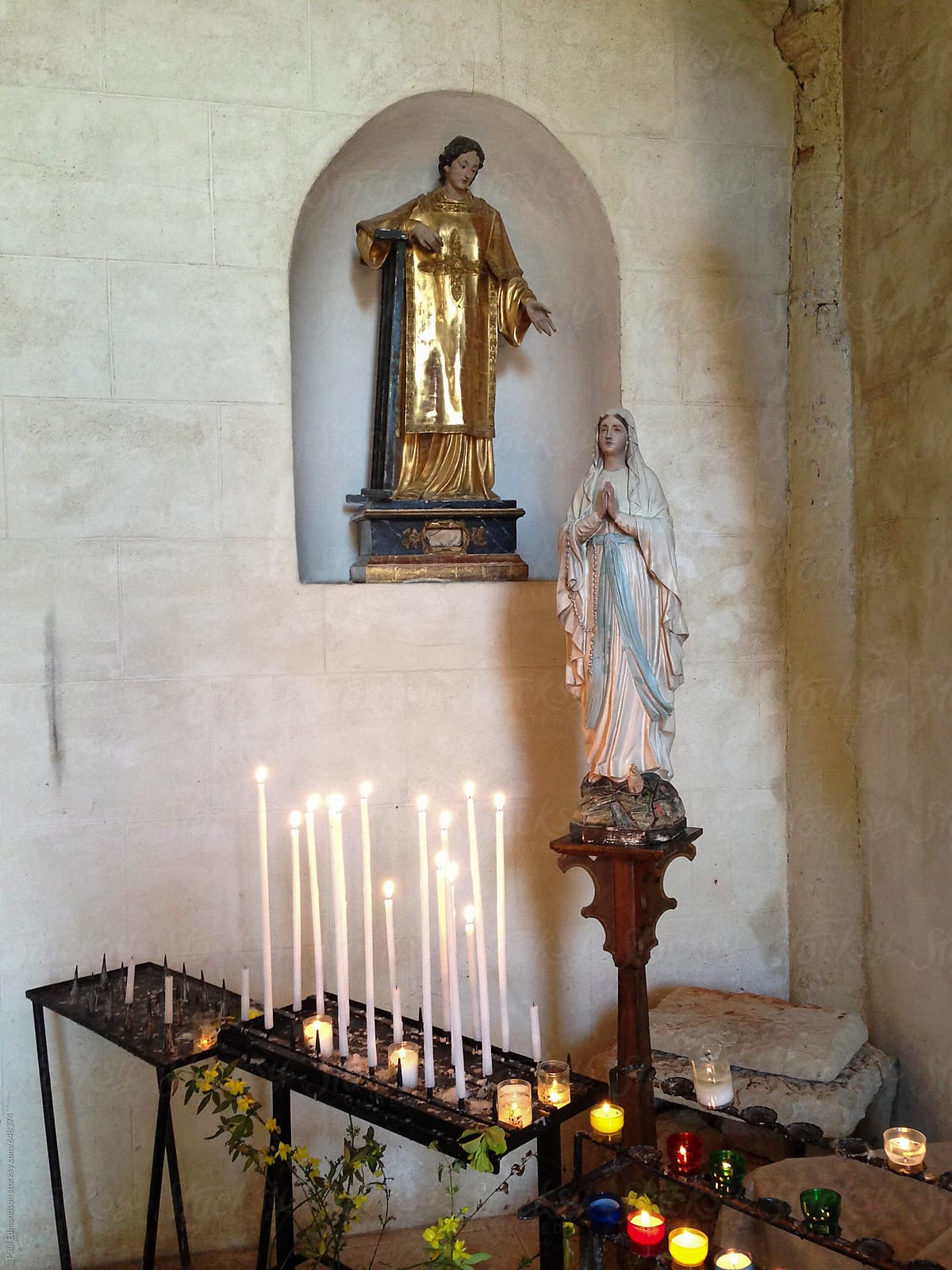 Interior of Catholic church, lit candles and religious icons, France