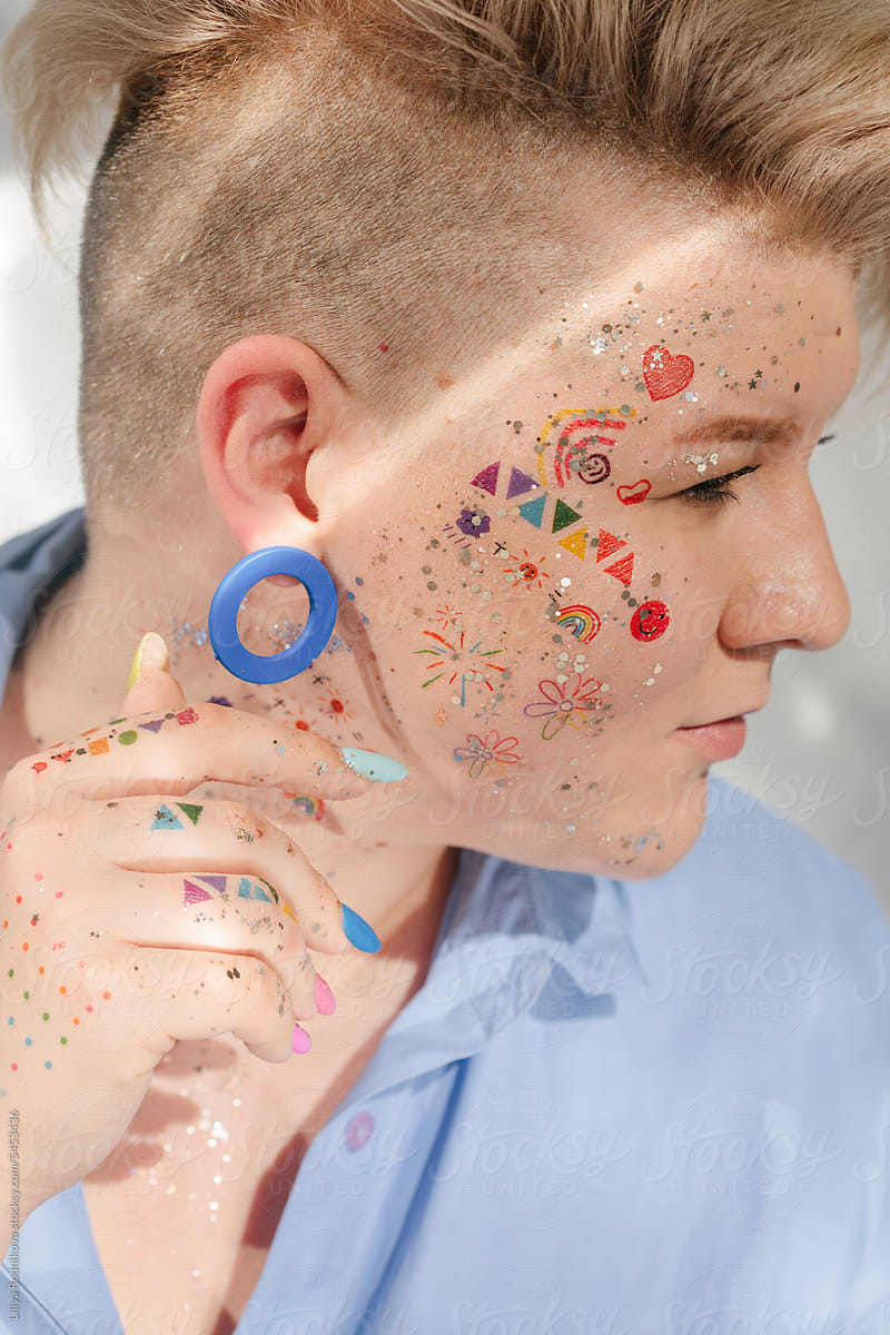 Profile portrait of person with many little stickers on face