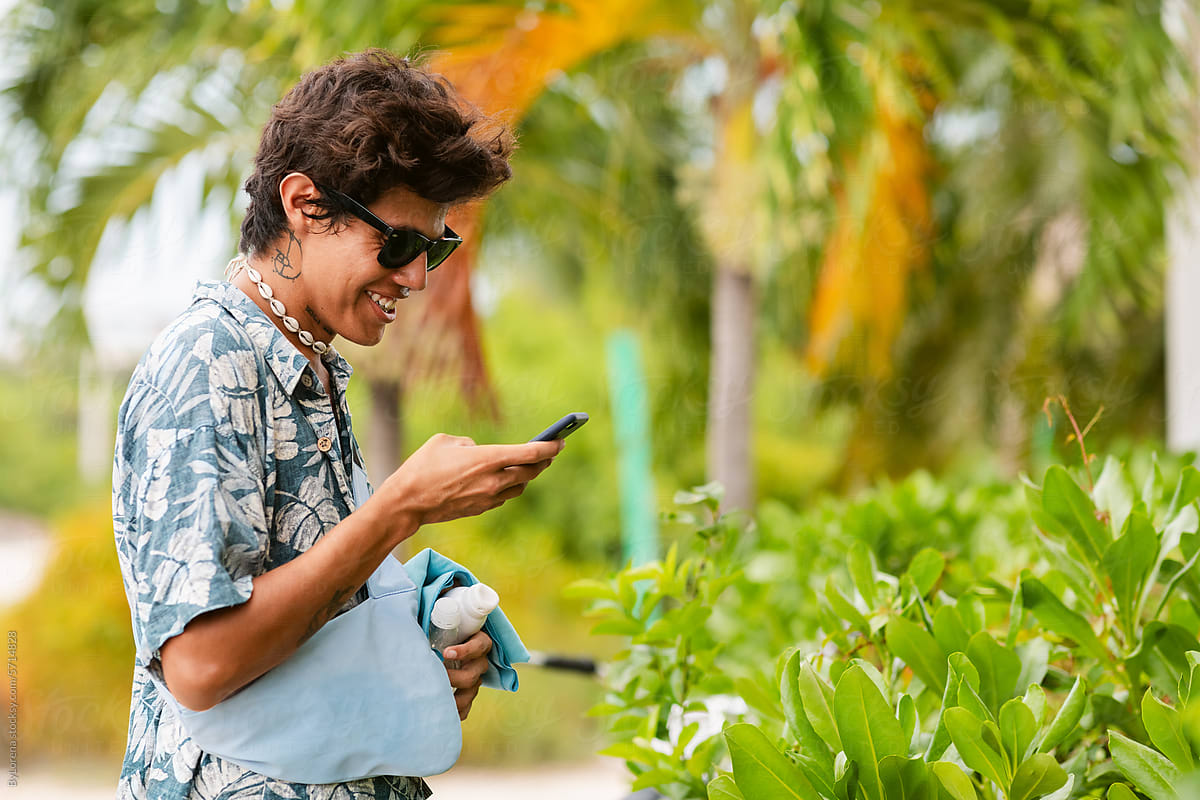 Young man using phone in the tropic