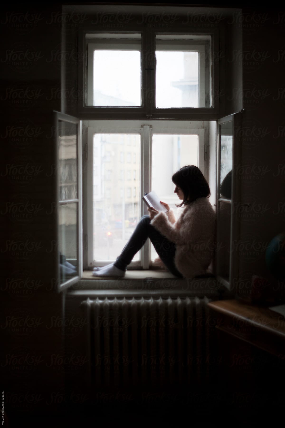 Girl reading a book in her room