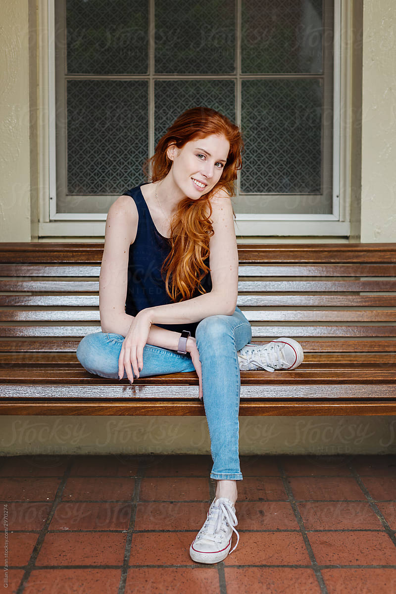 redhead woman sitting on bench