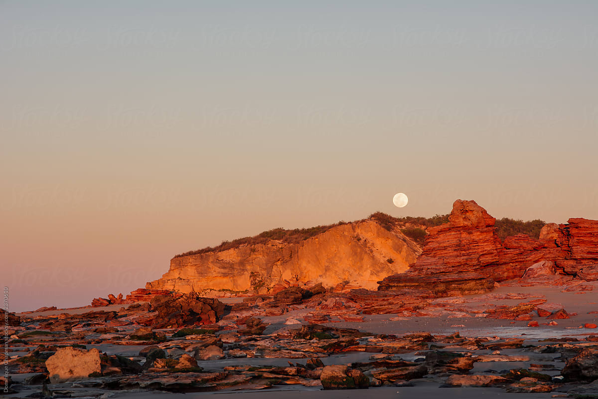Full moon rising over red cliffs