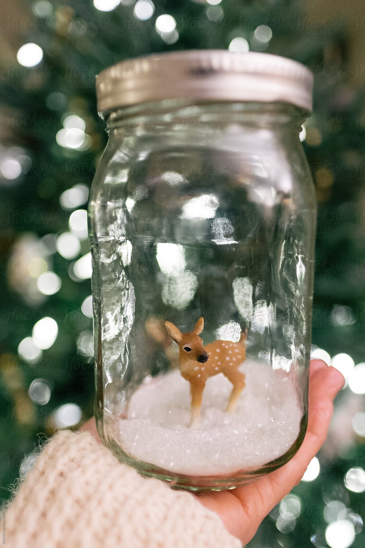 Hand holding deer in jar