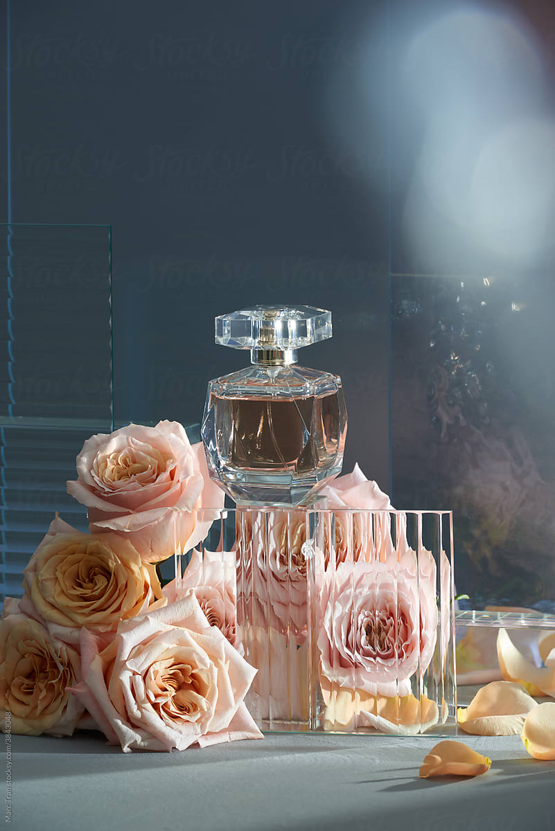 Perfume bottle with rose flowers background.