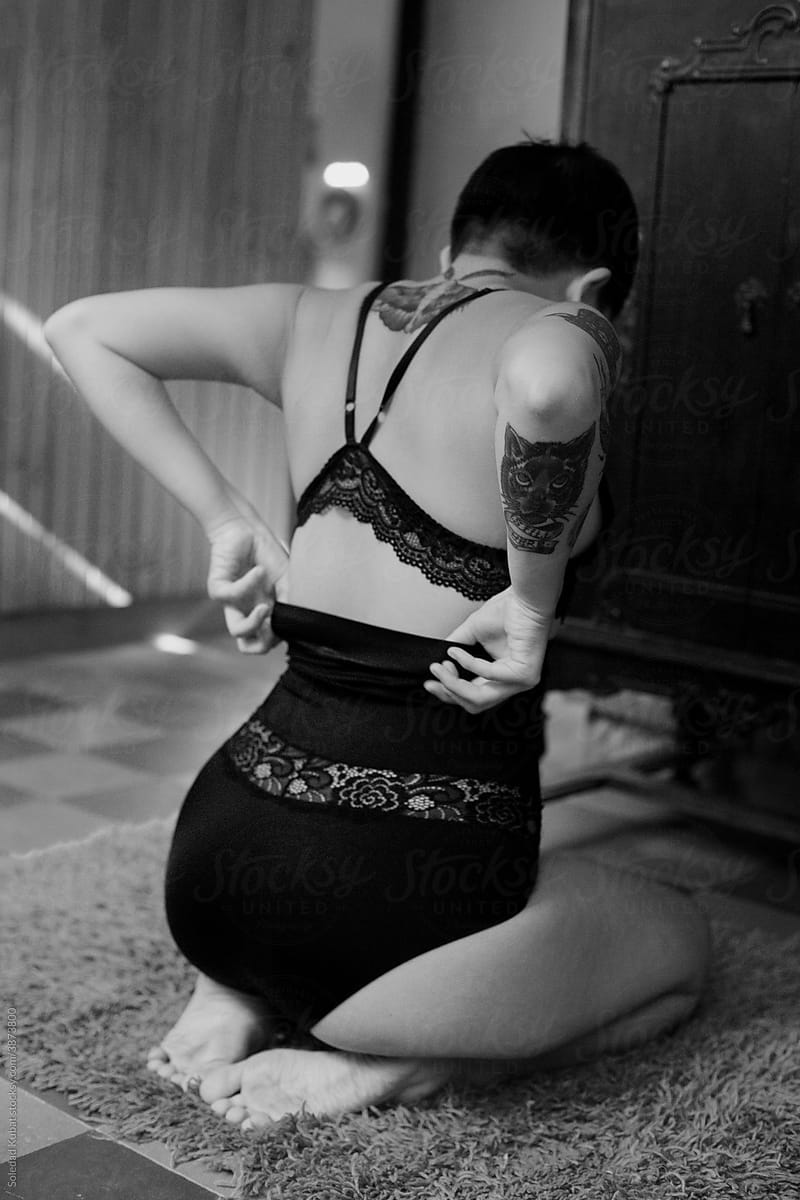 Sexy tattooed woman wearing underwear. Black and white portrait