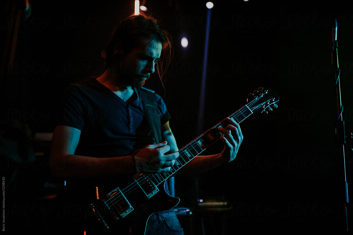 Young man playing an electric guitar on stage