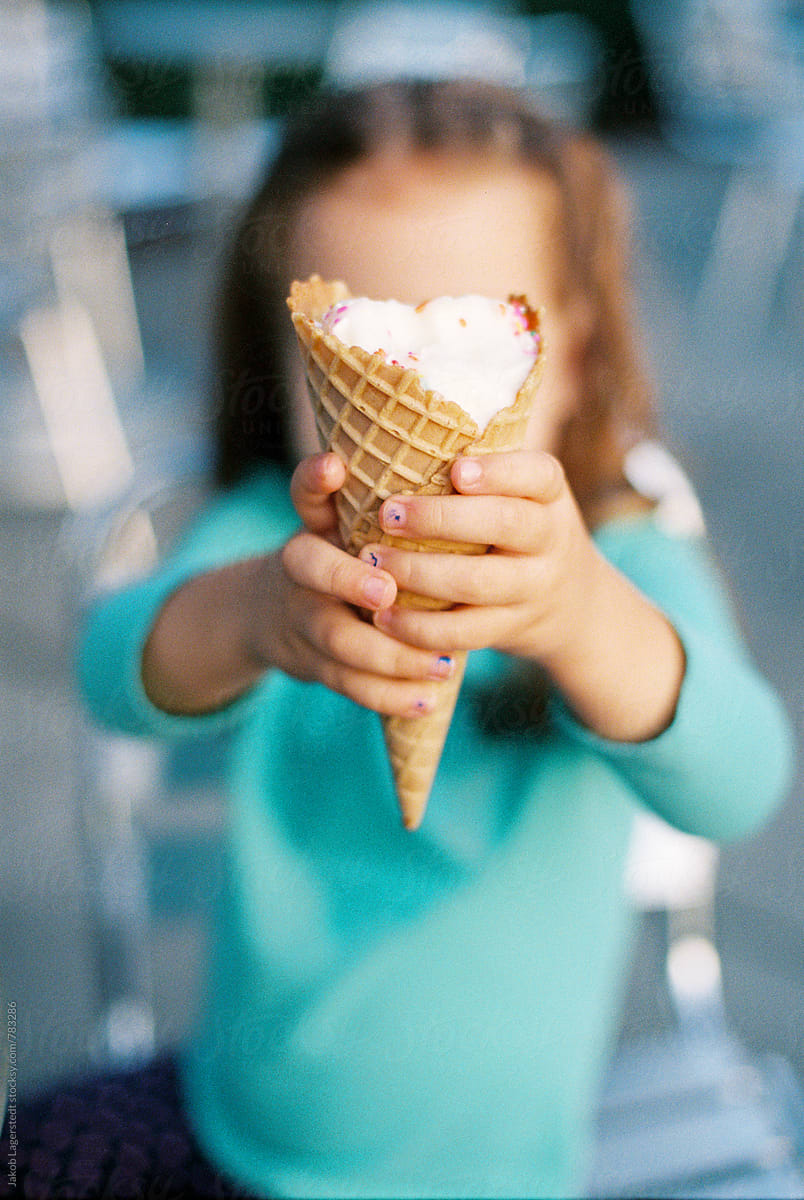 Young girl holding up a half eaten ice cream