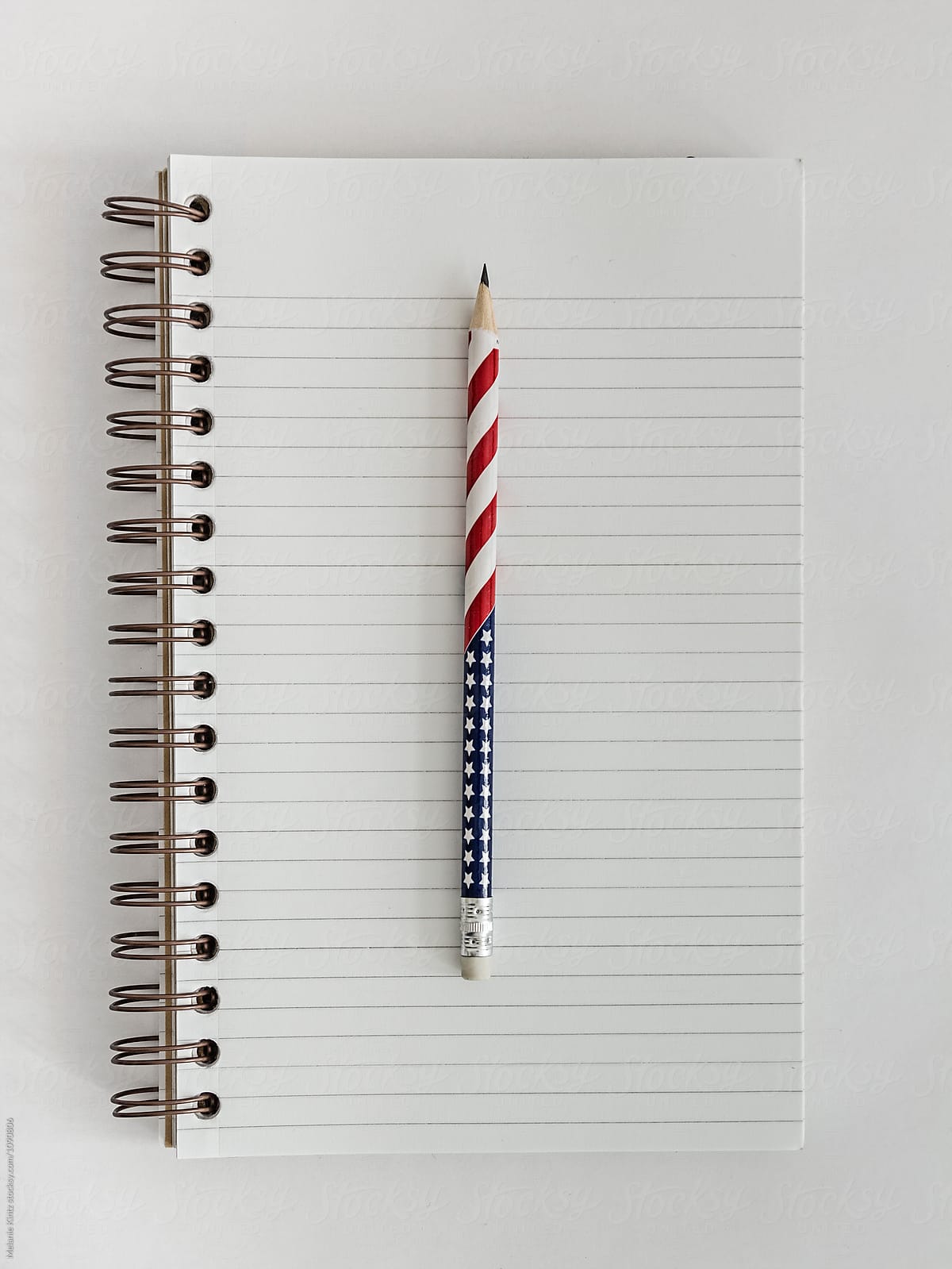 Open blank notebook with a stars and stripes pencil
