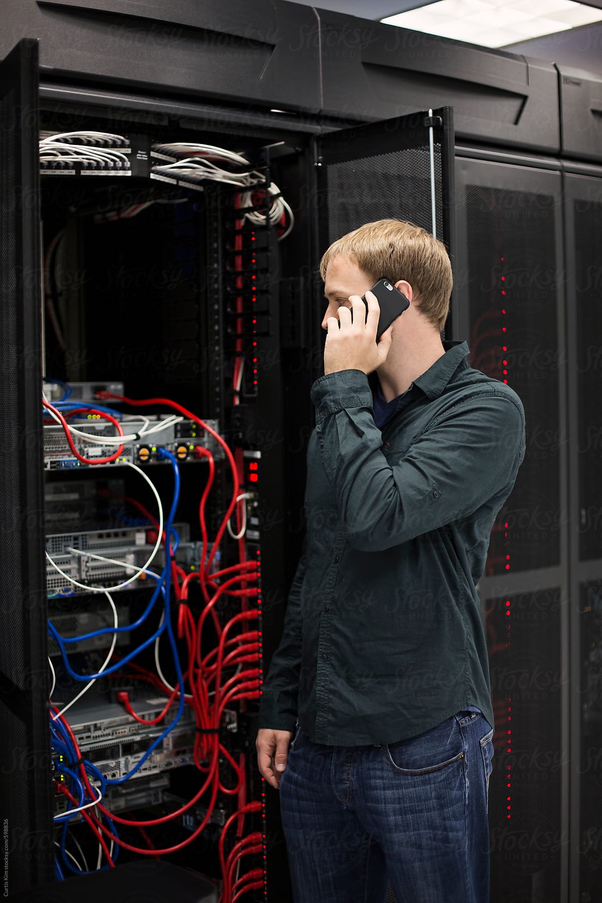 Computer programmer on the phone in server room