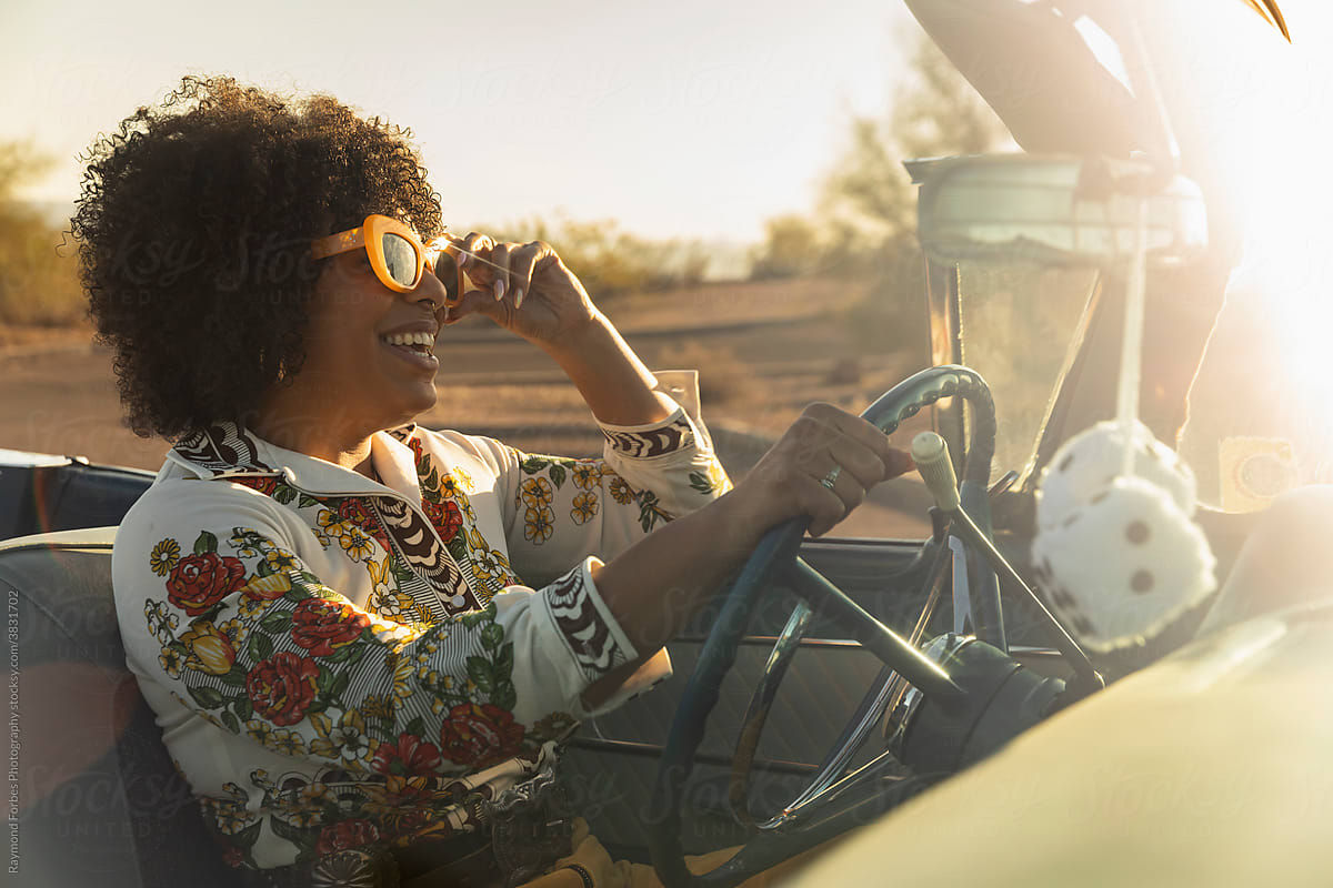 Beautiful Black woman in Vintage Car behind the wheel
