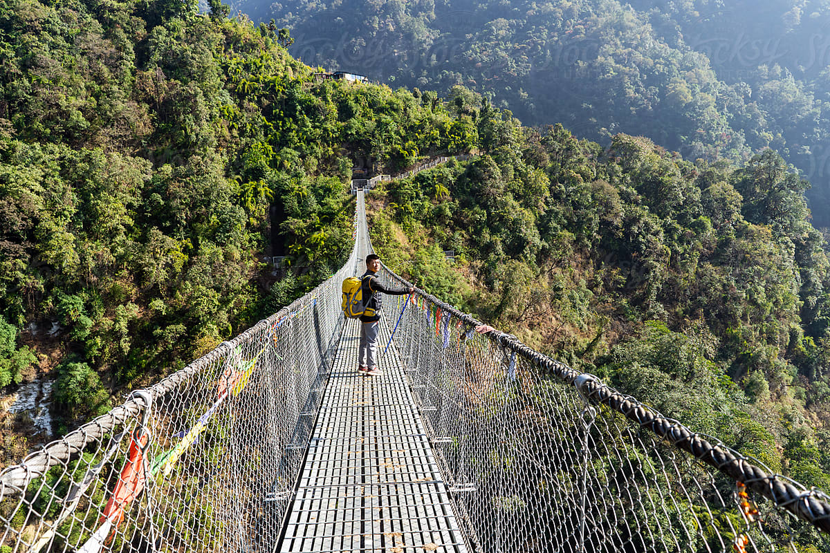 Man crossing suspended bridge in the Annapurna Himalaya Region
