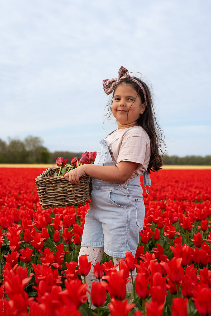 Girl standing with basket in tulip field