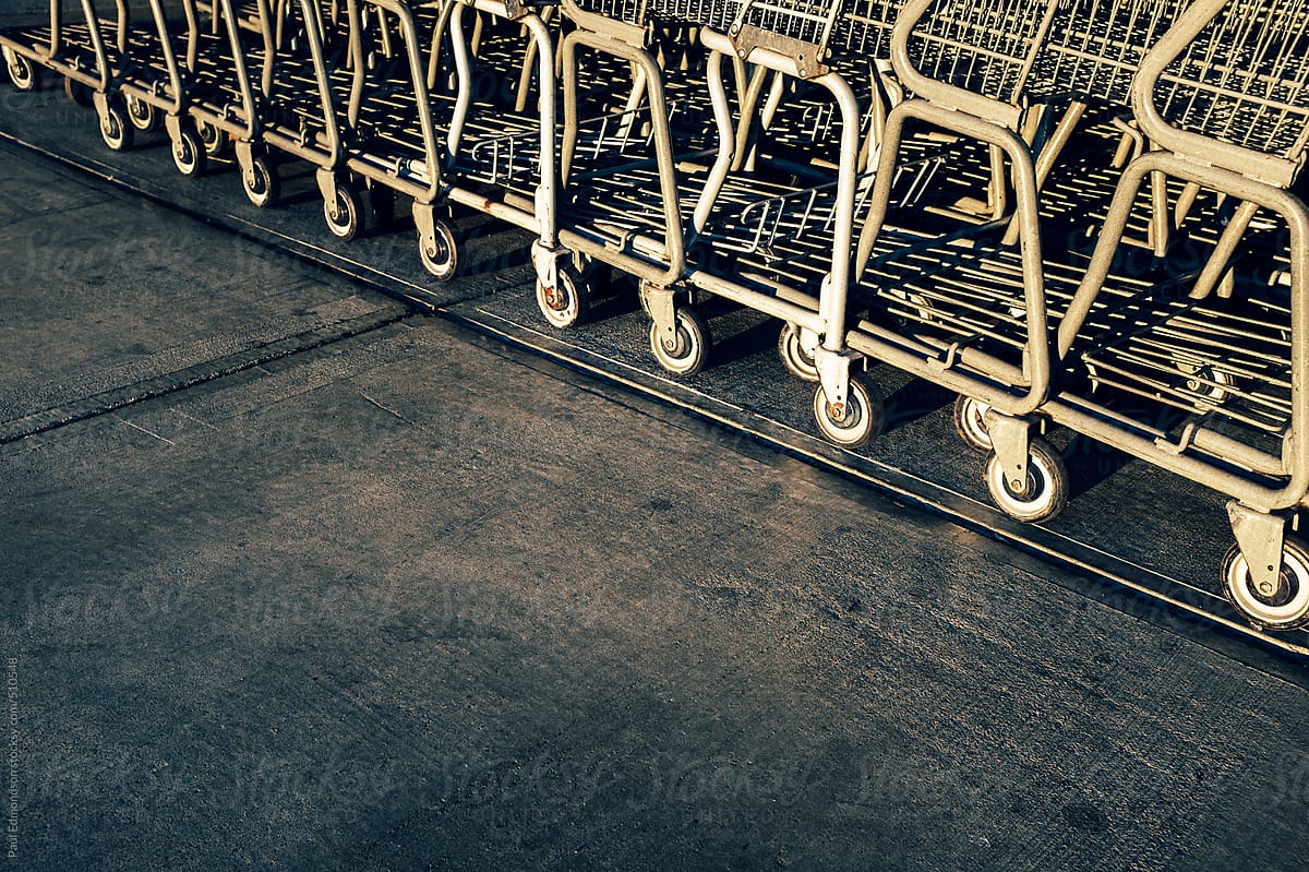 Metal grocery carts lined up on sidewalk outside supermarket