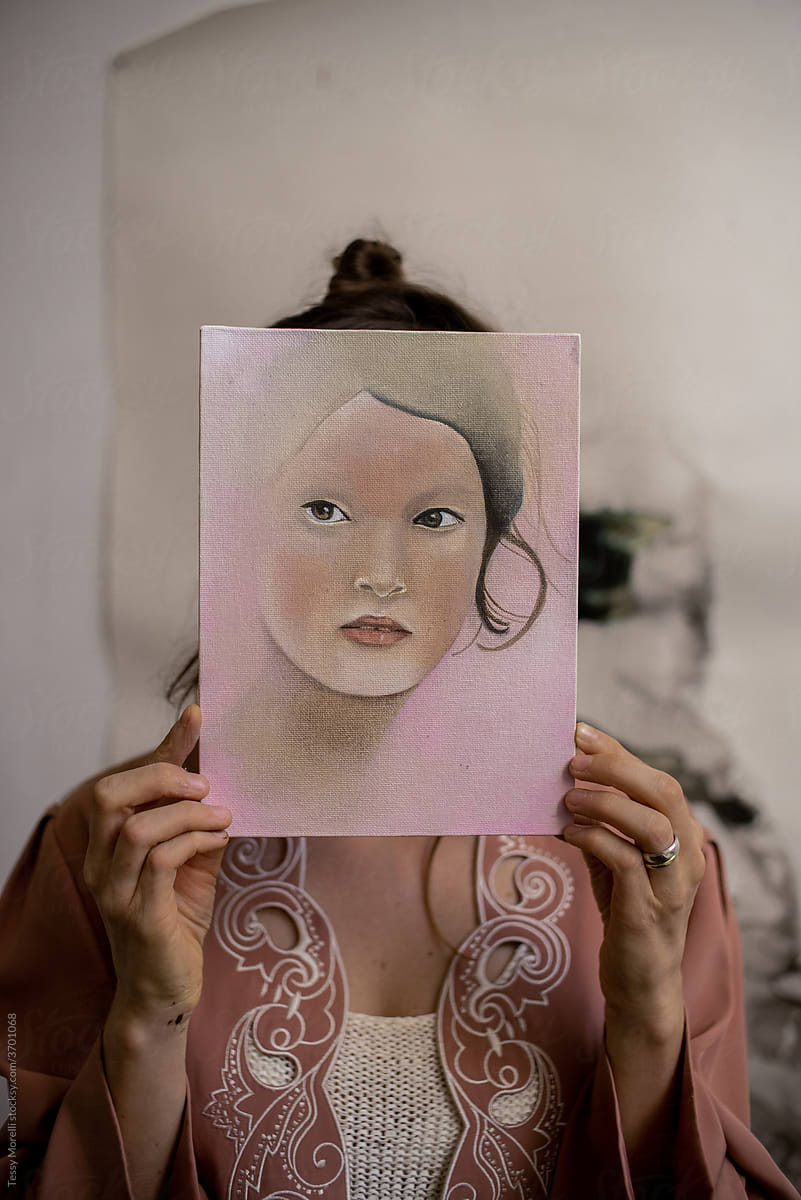 Artist holding a portrait with a face privacy concept